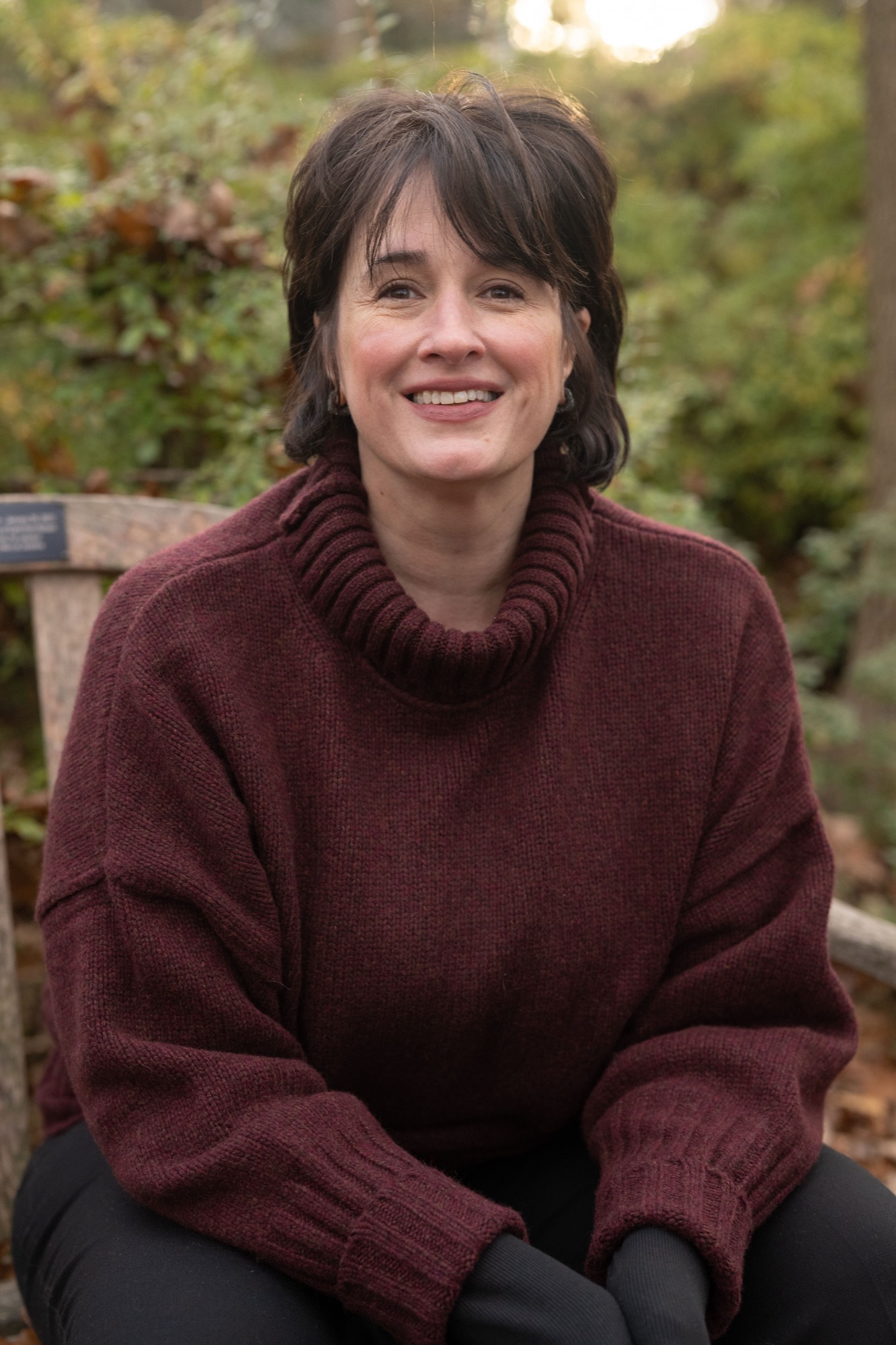 Tara on a garden bench in autumn light.